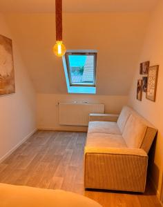 a living room with a couch and a window at Maison moderne entre terre et mer in Coquelles