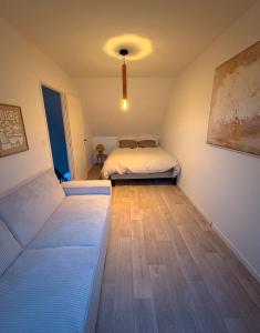 a bedroom with a bed and a wooden floor at Maison moderne entre terre et mer in Coquelles