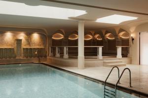 a swimming pool in a building with a swimming pool at Hotel Genziana in Ortisei
