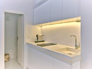 a white kitchen with a sink and a mirror at Beach House Mikri Santa Maria in Kournonísi +8 photos