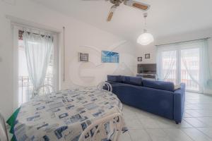 a living room with a blue couch and a table at Casa Malu in Marina di Campo