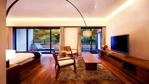 a bedroom with a bed and a television and a table at Premium Suites "Hanare Matsushimakaku" Produced by Shousuke no Yado Takinoyu in Aizuwakamatsu