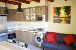 a kitchen with a couch and a washing machine at La Llacuna in Vila-Sana