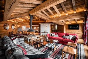 a living room with a red couch and a table at Chalets LA MOURRA in Val-d'Isère