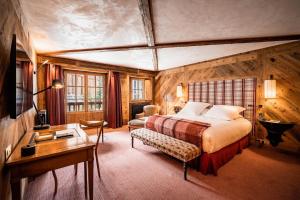 a bedroom with a bed and a desk in a room at Chalets LA MOURRA in Val-d'Isère +80 photos