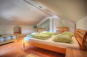 a bedroom with a large bed with green pillows at Bokun Apartments II in Sisak