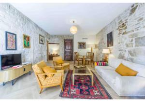 a living room with a white couch and a tv at Goncourt42 in Nîmes