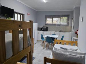 a room with a bed and a kitchen with a table at Zufike Self Catering in Port Elizabeth