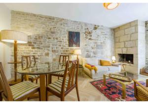 a living room with a table and a stone wall at Goncourt42 in Nîmes