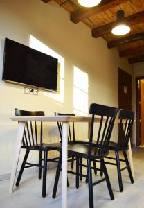 stół jadalny z krzesłami i telewizor z płaskim ekranem w obiekcie La Llacuna w mieście Vila-Sana