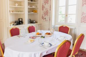 a white table with red chairs and a table with food on it at Château Bellevue-Domaines Loron in Villié-Morgon