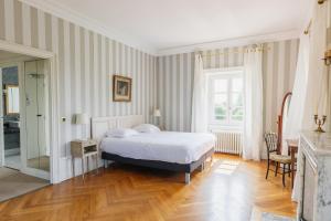 a bedroom with a bed and a table and a mirror at Château Bellevue-Domaines Loron in Villié-Morgon