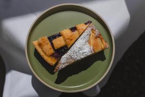 a plate with a piece of cake with powdered sugar on it at Borgo di Colleoli Resort in Colleoli