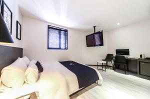 a bedroom with a bed and a desk with a computer at 엘루이호텔 in Busan