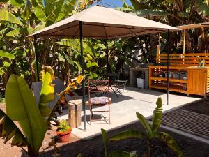 a patio with an umbrella and a table and a chair at Cabaña Yan-Yan, refugio natural en valle de Azapa - Arica in Arica