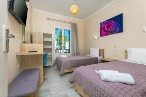 a hotel room with two beds and a window at Potamos Apartments in Sidari