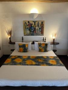 a bedroom with a large bed with a painting on the wall at O'Sole Mio Assinie in Assinie