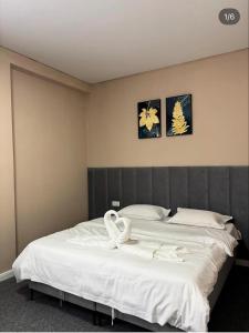 a bedroom with a large white bed with swans on it at Барыс in Almaty