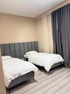 a room with two beds in a room at Барыс in Almaty