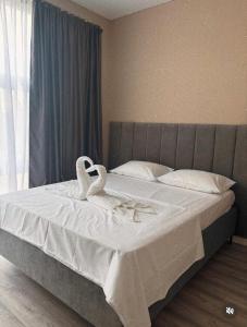 two swans sitting on a bed in a bedroom at Барыс in Almaty