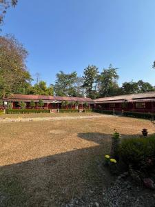 a large building with a lot of gravel and trees at Gorumara Jungle Resort in Chālsa