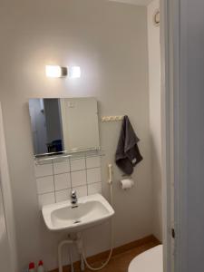 a white bathroom with a sink and a mirror at Opiskelijankatu 5 Varkaus in Varkaus