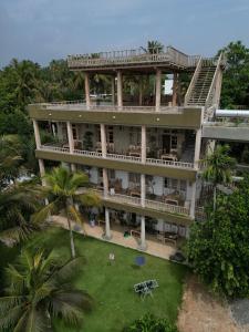 an aerial view of a building with a lawn and palm trees at Wilson's Place in Hiriketiya