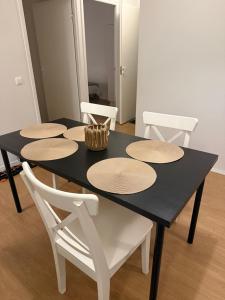 a black dining room table with white chairs around it at Opiskelijankatu 5 Varkaus in Varkaus