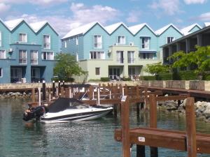 a boat docked at a dock in front of houses at 9/20 Apollo Quay Apartment in Mandurah