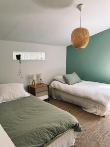 a bedroom with two beds and a pendant light at La maison de Juliette in Céret