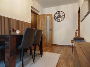 a dining room with a table and chairs and a clock at Apartmán Vráž u Písku in Písek +16 photos