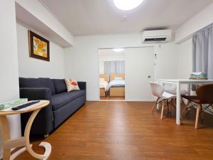 a living room with a couch and a table at OLIVE Stay in Fukuoka