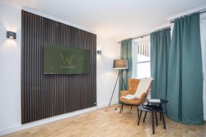 a living room with a chair and a television on a wall at UplandParcs W3 in Winterberg