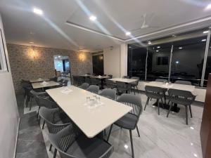 a dining room with tables and chairs and windows at Hotel Soham Retreat in Mahabaleshwar