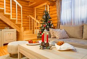 a living room with a christmas tree and candles on a table at Hotel Yastrebets Wellness & Spa in Borovets +81 photos