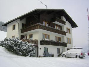 a building with a car parked in the snow at Haus Mitterrutzner in Kartitsch