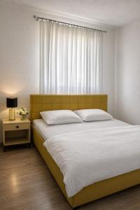 a bedroom with a large bed and a window at Apartmani Sun & Moon in Žepče