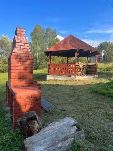 a brick structure with a gazebo in a field at Casa Santa Maria Bran in Moieciu de Jos