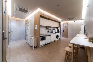 a large kitchen with white cabinets and a table and chairs at HiMate Dongdaemun in Seoul