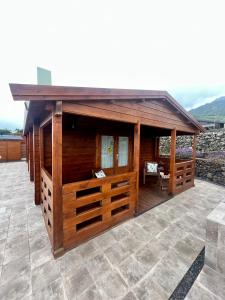 a large wooden building on a patio at Betenama - Rustic Hideaway with Pool & Garden in Tesbabo