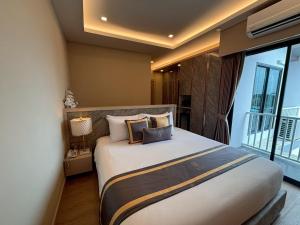 a bedroom with a large bed and a balcony at Bestier Hotel Hatyai in Hat Yai