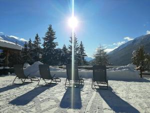 a group of chairs in the snow with the sun at Residence Mirage in Oga