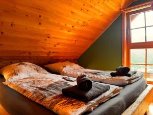 two beds in a room with wooden ceilings at Ottls Huette in Sankt Lorenzen ob Murau