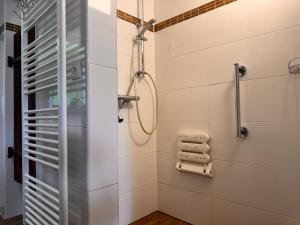 a shower in a bathroom with white tiles at Wind Buam Huette in Sankt Lorenzen ob Murau +16 photos