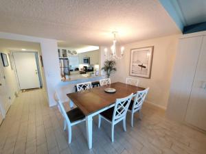 a dining room with a wooden table and chairs at Summerhouse 104- Direct Oceanfront condo in St. Augustine
