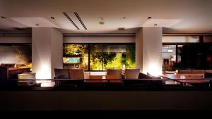 a dining room with chairs and a large aquarium at Aizu Higashiyama Onsen "Shosuke no Yado Takinoyu" since1880 in Aizuwakamatsu