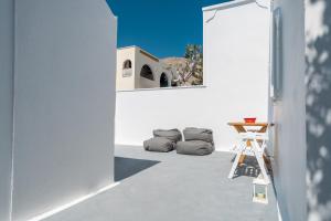 a room with a white wall and a ladder and a mirror at Coastal Escape - 2 min from Perissa Beach in Perissa