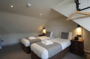 two beds in a room with a attic at The Whisky Vaults in Oban
