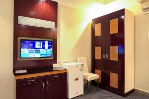 a room with a refrigerator and a tv on a wall at فندق ام جي كراون 3 - MG Crown Hotel 3 in Medina