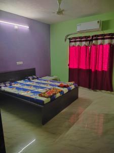 a bedroom with a bed and a red curtain at Kadaiya house in Marwad